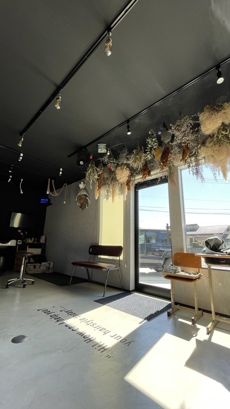 HAIR BOX 4番館 の店内。黒い天井とドライフラワー、コンクリートの床に差し込む光